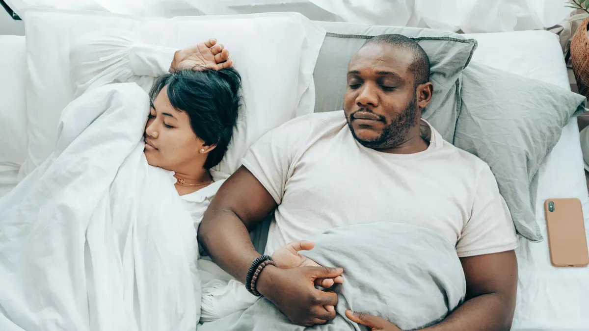 Thermometer showing 24°C in a bedroom with elderly person sleeping peacefully