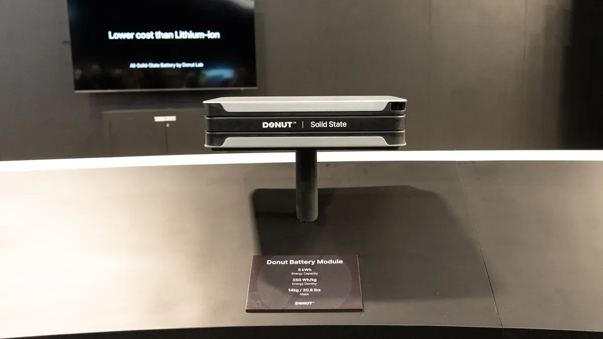 Donut Lab's solid-state battery prototype displayed at CES 2026 with Verge TS Pro motorcycle in background