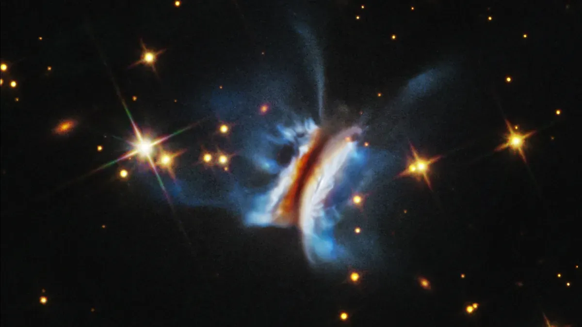 Hubble Space Telescope image of the edge-on protoplanetary disk IRAS 23077+6707, showing asymmetric vertical filaments and a sharp edge.
