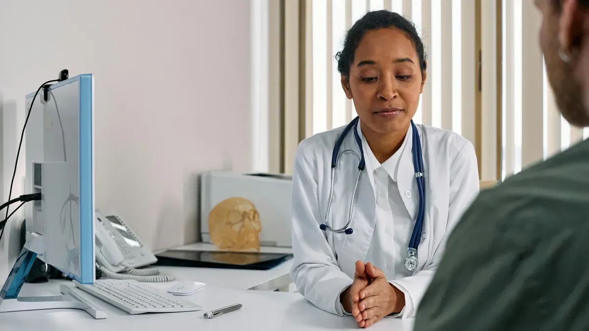 A person checking their calendar while at a doctor's office, highlighting scheduling conflicts between work and healthcare appointments