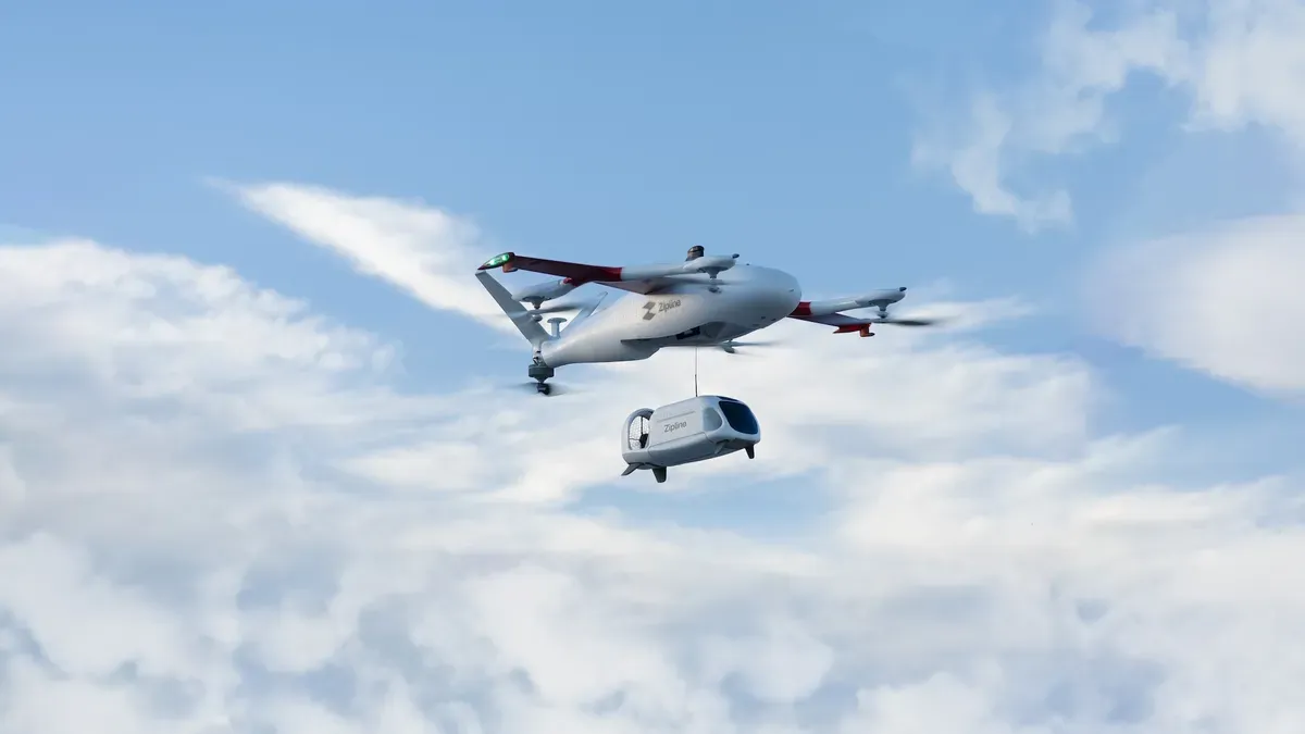 Zipline drones in flight with warehouses in the background